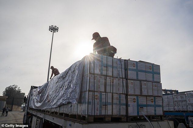 Members of the Egyptian Red Crescent prepare aid trucks in anticipation of their entry into the Gaza Strip at the Rafah crossing between Egypt and Gaza on July 28