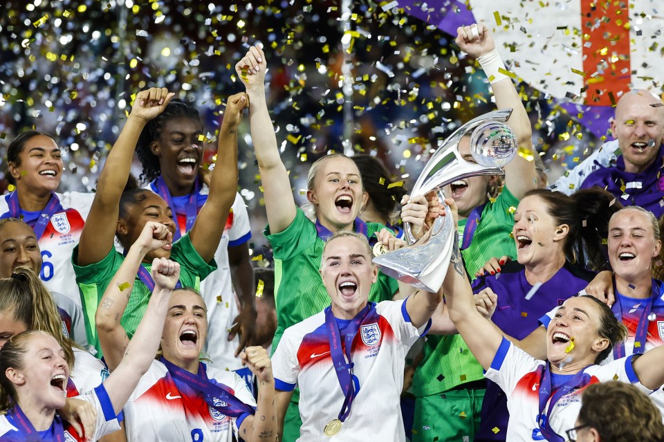 England's Women's Euro winning team celebrating with the trophy.
