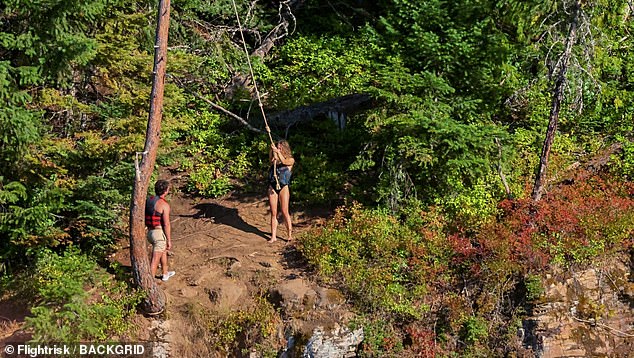 The handsome man appeared to be encouraging her as he smiled proudly at her as she jumped off the cliff and dived into the water