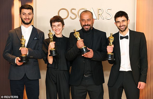 No Other Land co-directors (left to right) Basel Adra, Rachel Szor, Hamdan Ballal and Yuval Abraham clutch their awards after winning Best Documentary at this year's Oscars