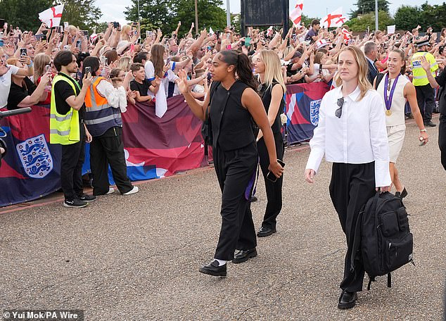 England's Chloe Kelly (centre), Keira Walsh (right) and goalkeeper Khiara Keating (centre left) greet fans after arriving at London Southend Airport