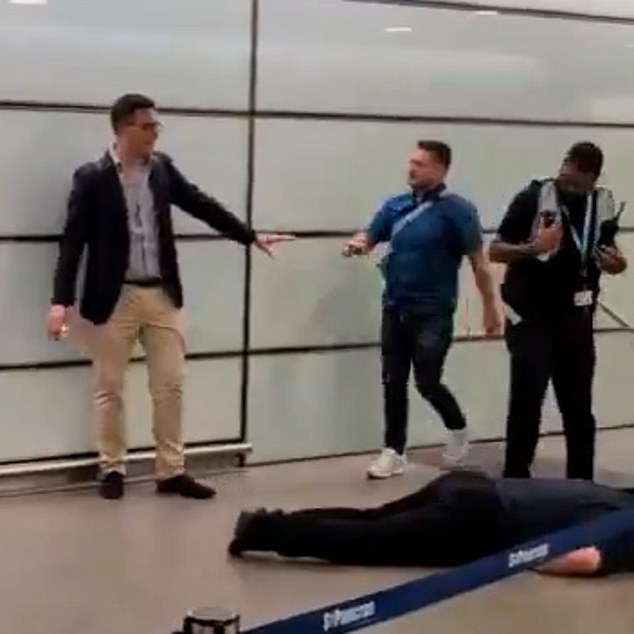 Robinson, visibly agitated, throws his arms in the air before turning and walking away down a staircase, repeatedly protesting his innocence: 'He f***ing came at me, bruv. He come at me bruv, you saw that.'