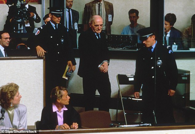 Barbie being led to the dock at his trial in Lyon, 1987