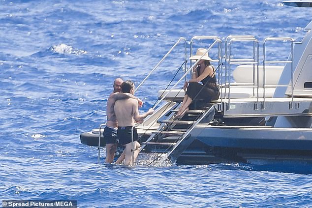 After settling in, Cruz enjoyed a dip in the ocean with his father, 50, before sharing a sweet embrace while chatting to Victoria