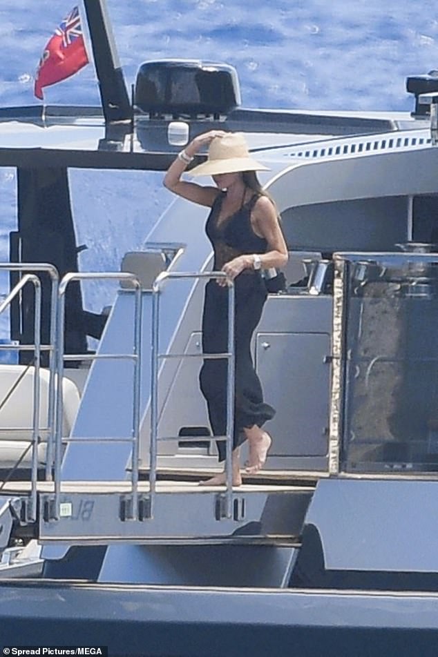 Fashion designer Victoria looked incredibly elegant in a black lace dress, teamed with a large sun hat
