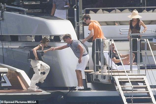 A crew member helped Jackie step onto the yacht