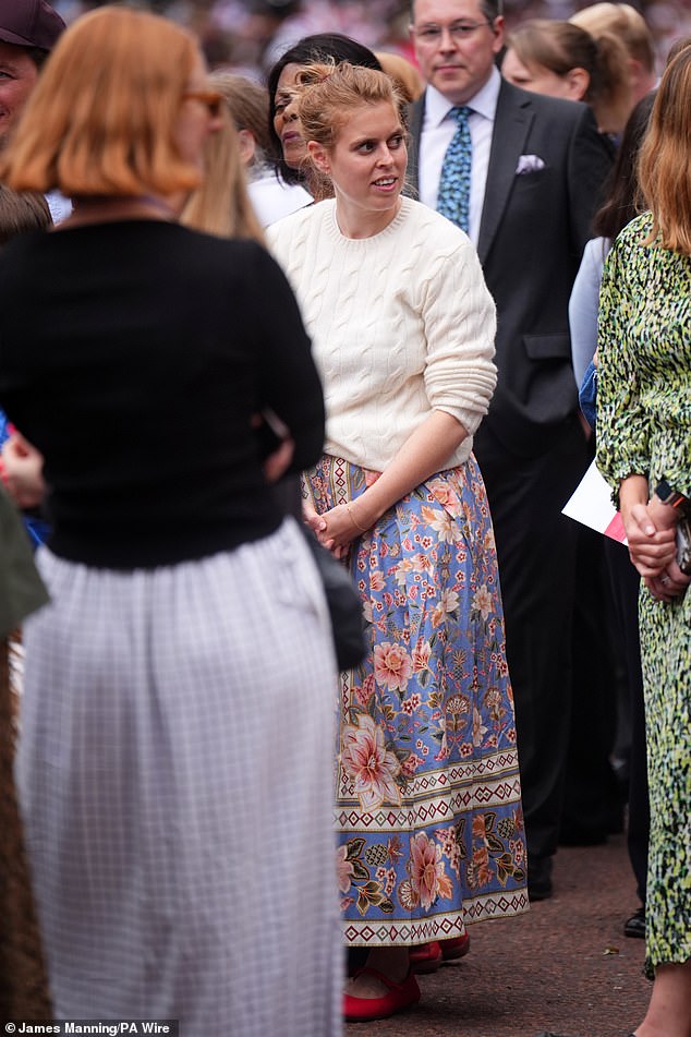Beatrice pulled her hair back into a messy bun and dressed for cooler weather in London today as she paired a cream sweater with a blue, floral print skirt from Farm Rio