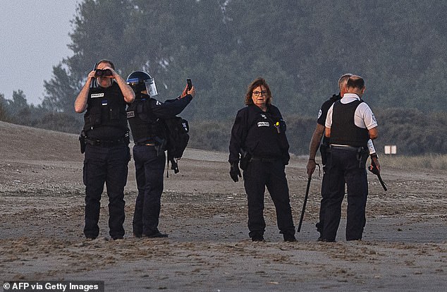 One officer even appeared to be taking a selfie moments after the boat set sail towards the English coast