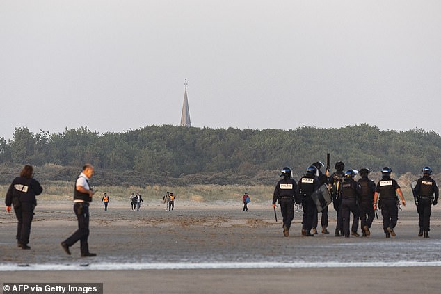 The officers then saunter off just as another group wearing fluorescent life jackets and carrying bags start making their way to the water's edge