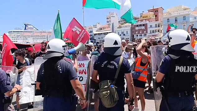 Activists use a megaphone to speal to the crowd who assembled to protest the arrival of the Israeli cruise ship