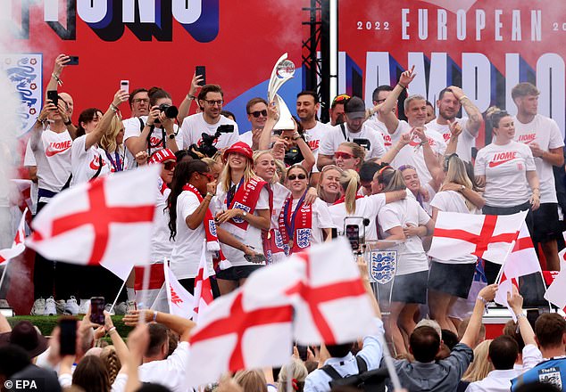 Fans go wild in celebration, waving England flags as the Lionesses celebrate on stage together