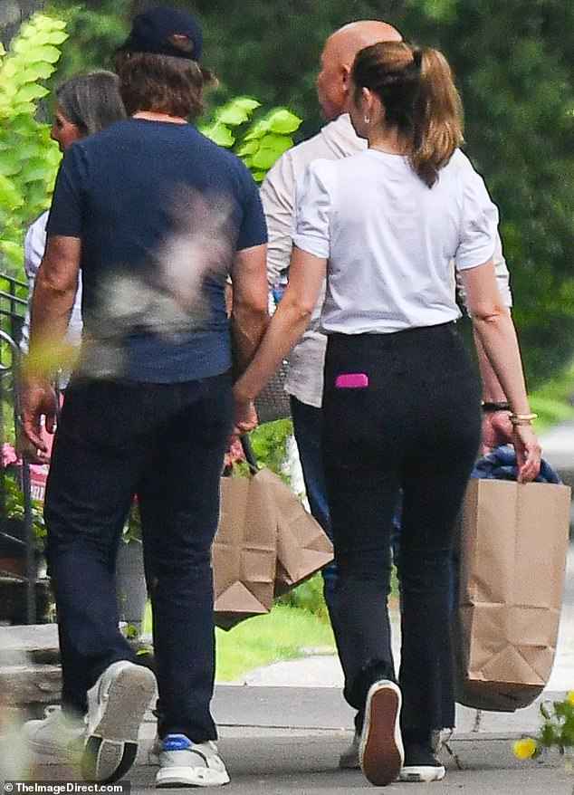 Her hand was clasped firmly in his when they were seen ambling up a tree-lined sidewalk in the village of Woodstock
