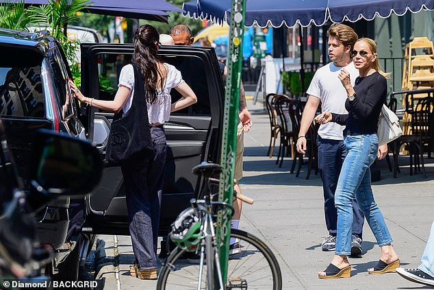 Claudia looked chic in a navy long-sleeved top, jeans and wedges