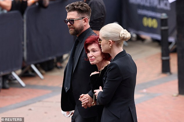 She was supported by children Jack, Kelly and Aimee (pictured: Jack and Kelly holding her by the arms as she walks)