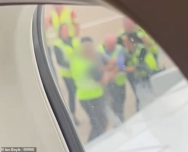 Both men were dressed in casual clothing with one appearing to don a pair of shorts while another bald man looked like he was wearing a blue shirt