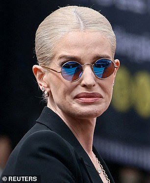 Kelly broke down in tears while wearing her father's trademark purple-lens glasses at the funeral procession