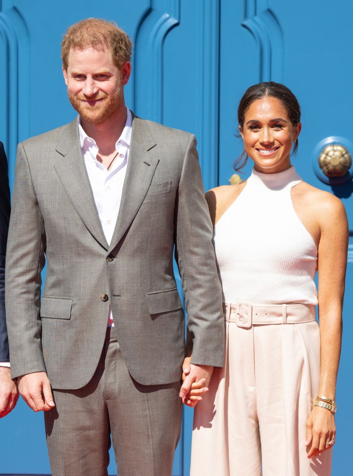 Prince Harry and Meghan Markle holding hands at the Invictus Games Düsseldorf 2023 launch event.