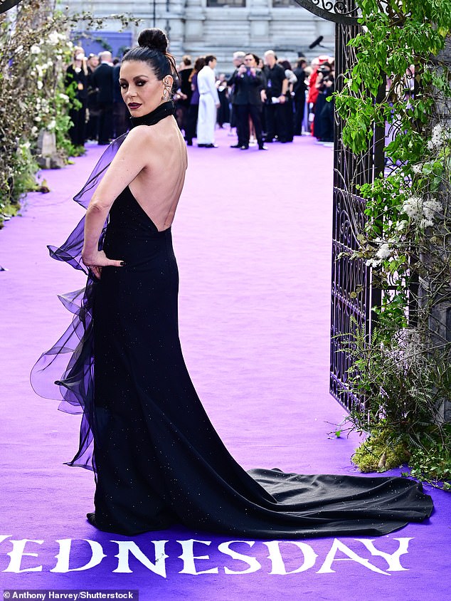 Catherine, 55, who stars as Addams family matriarch Morticia, wore a dramatic backless gown with a highneck and key-hole cut out