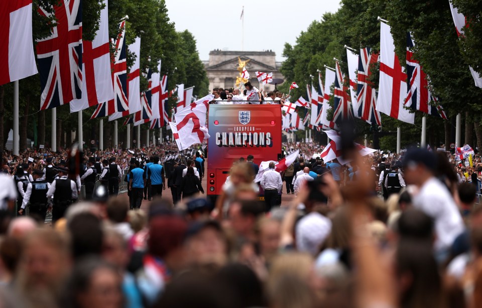 The England Women's football team riding on a bus in a victory parade down The Mall in London.