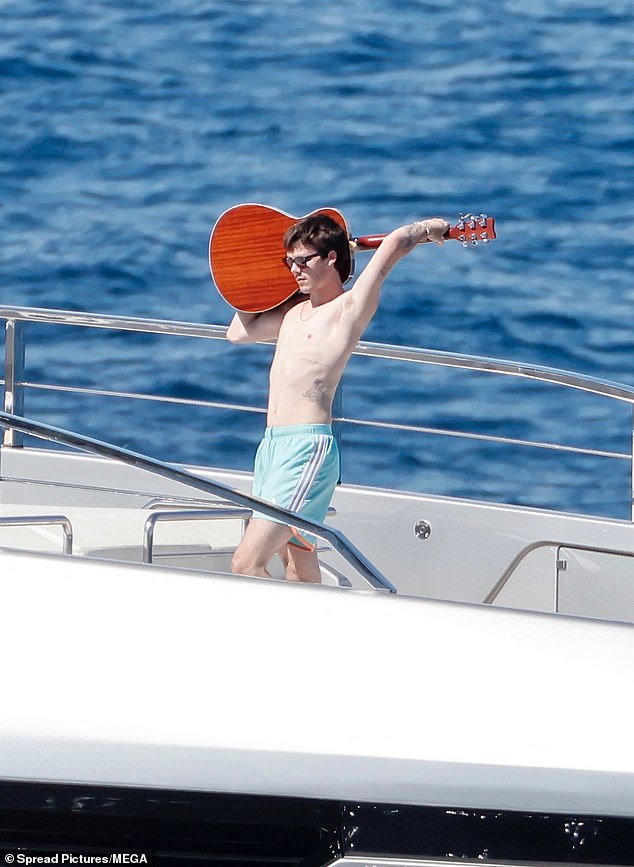 Budding musician Cruz in looked every inch the showman as he played guitar on the front of the impressive vessel in front of his girlfriend