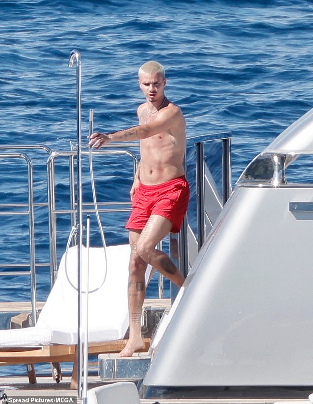 Shirtless Romeo donned a pair of red swimming shorts