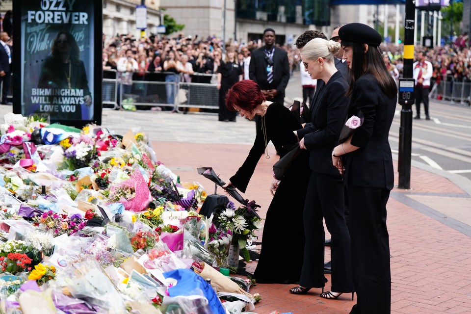 Sharon Osbourne and family members laying flowers at a memorial.