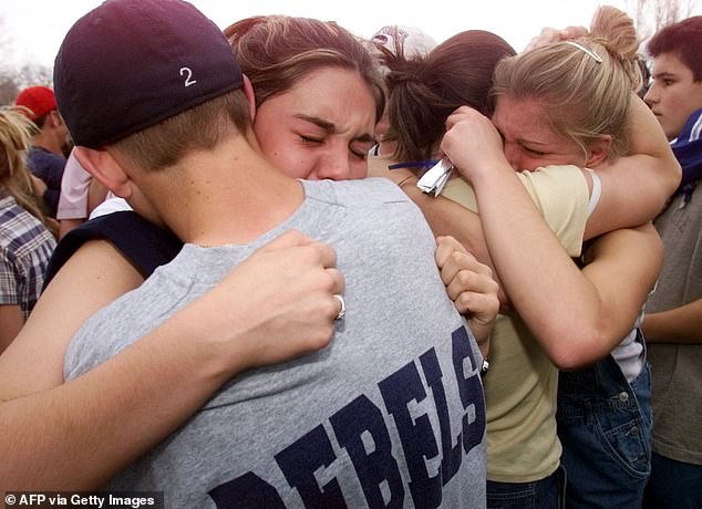 Students hug one another in the aftermath of the tragic school shooting, which was carried out by two former pupils