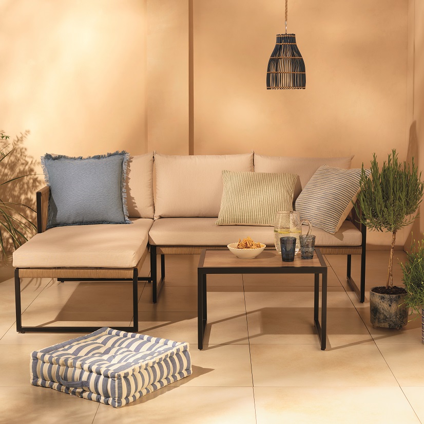 Beige corner sofa set with blue and green pillows and a coffee table.