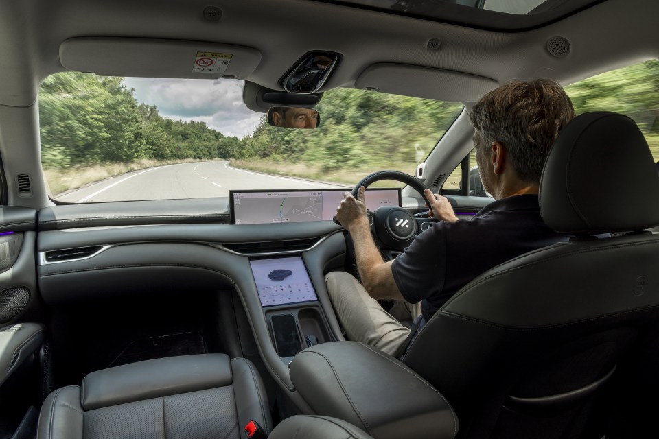 Man driving a car on a country road.