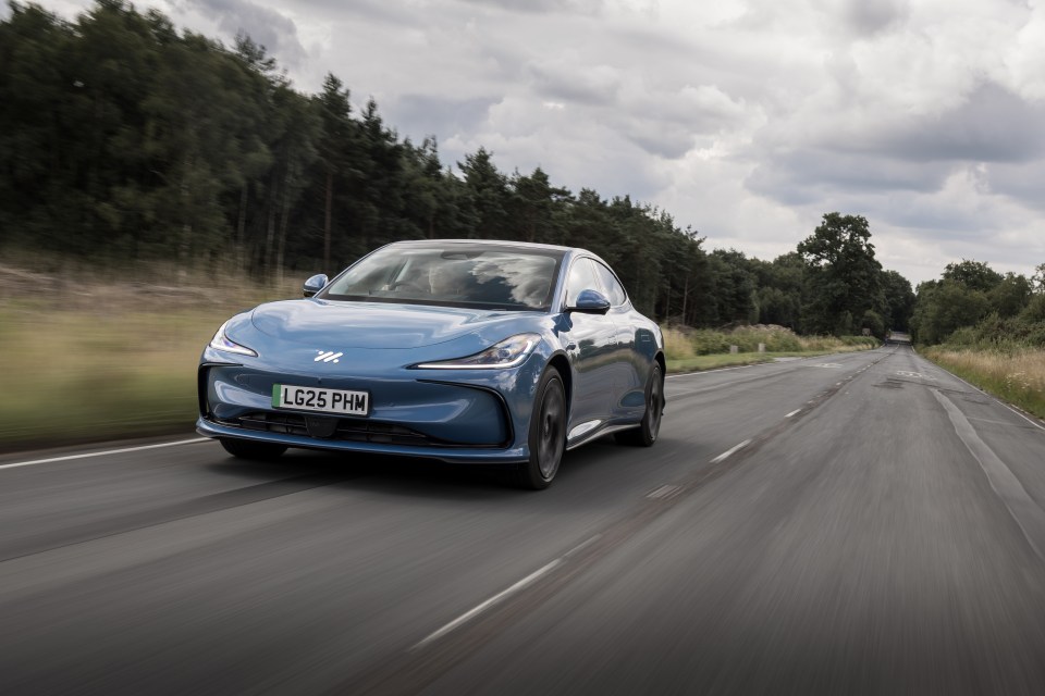 Blue electric car driving on a road.