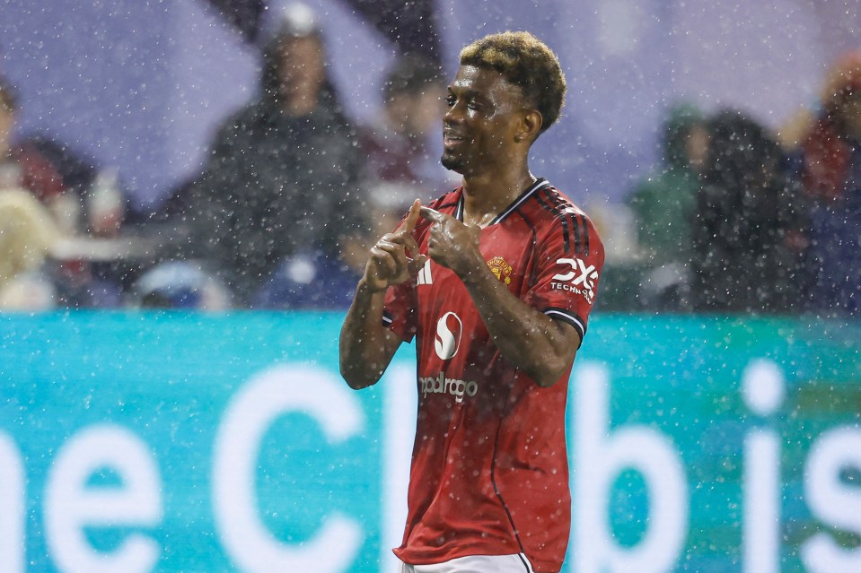 Amad Diallo of Manchester United celebrates scoring a goal in the rain.