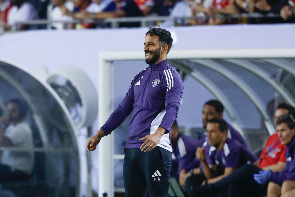 Ruben Amorim, Manchester United coach, smiling on the sidelines.