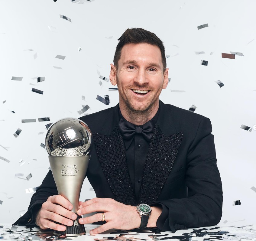 Lionel Messi holding a Best FIFA Men's Player award.