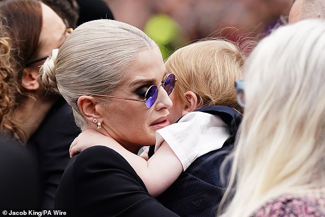 Kelly wore Ozzy's trademark purple glasses in a heartbreaking nod to her father at his funeral procession today