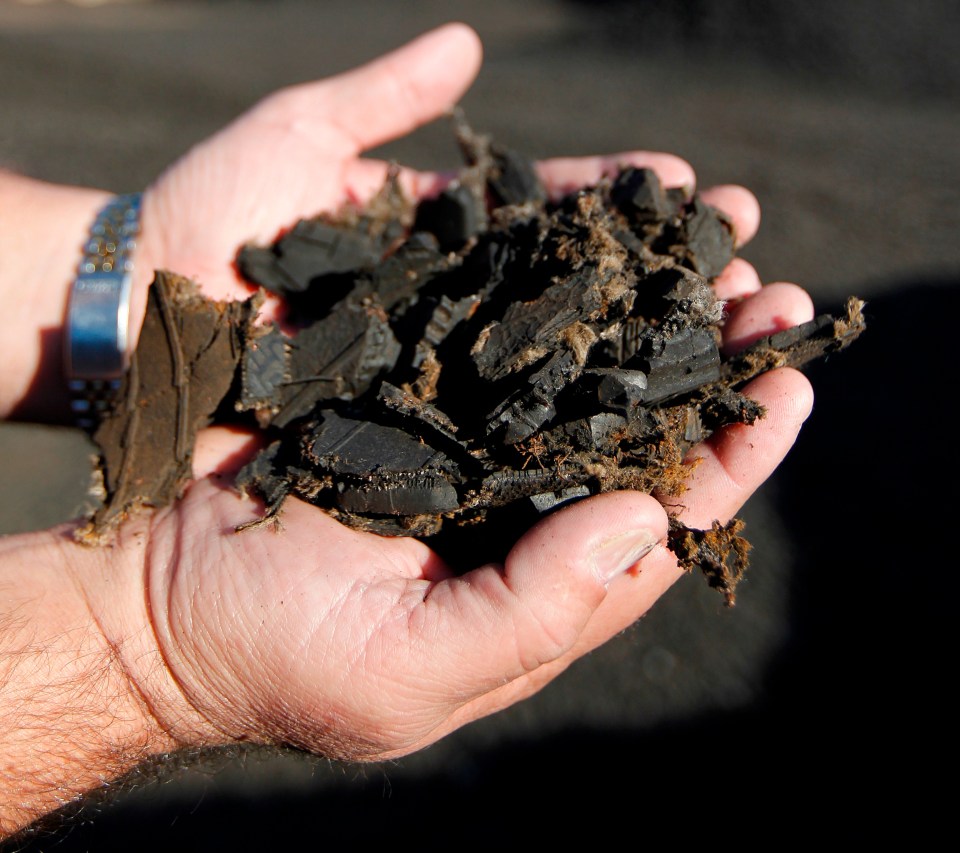 Hands holding recycled tire mulch.