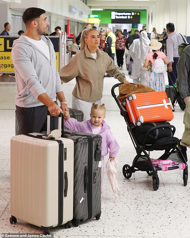 Molly-Mae looked restless as she prepared to board a Jet2 flight with partner Tommy and their daughter Bambi after arriving at a busy Manchester Airport on Thursday