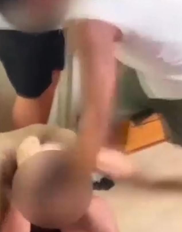 While the three carried out the attack, another could be seen filming it. The boy is seen here being punched in the head as he sat on the floor