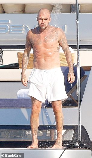 David showed off his toned frame as he went shirtless in the beachwear look while soaking up the sun