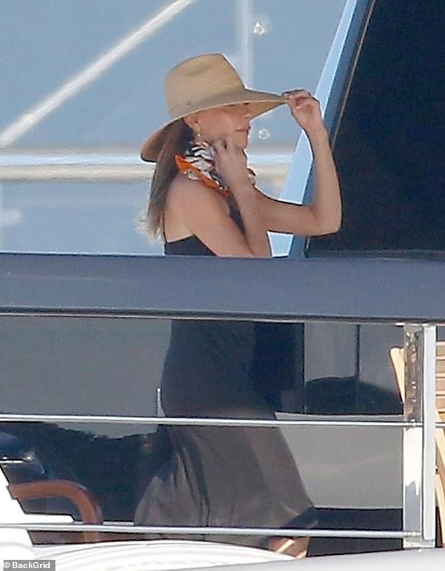 For the outing, Victoria cut a stylish figure in a white dress, which she paired with a wide-brimmed straw hat and an orange scarf