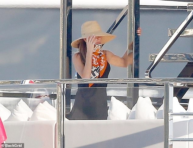 Fashion designer Victoria shielded her face from the bright sunshine with a wide-brimmed straw hat