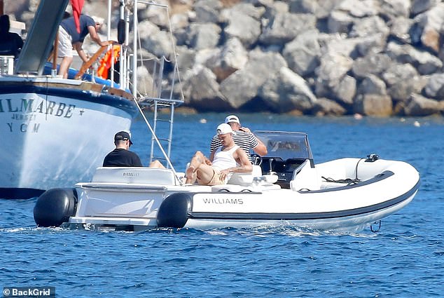 Romeo cut a trendy figure in a white vest and matching shorts, which he styled with a white snapback hat