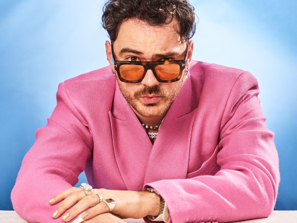 Portrait of Cian Ducrot wearing a pink blazer and sunglasses.