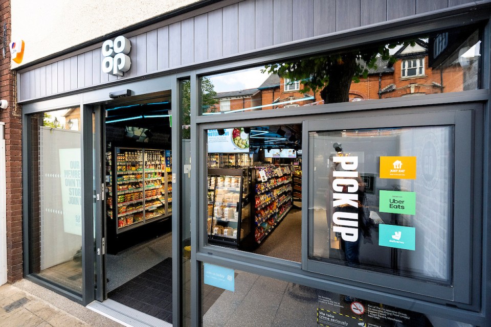 Exterior view of a Co-op On The Go convenience store with a pick-up area for food delivery services.