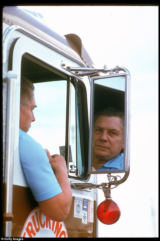 Pictured: Hoffa driving one of his trucks as he looks in the mirror and appears somber. The photo was taken in January 1975, approximately six months before he went missing