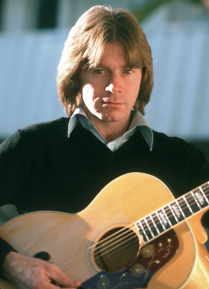 Photo of Dave Edmunds with an acoustic guitar.
