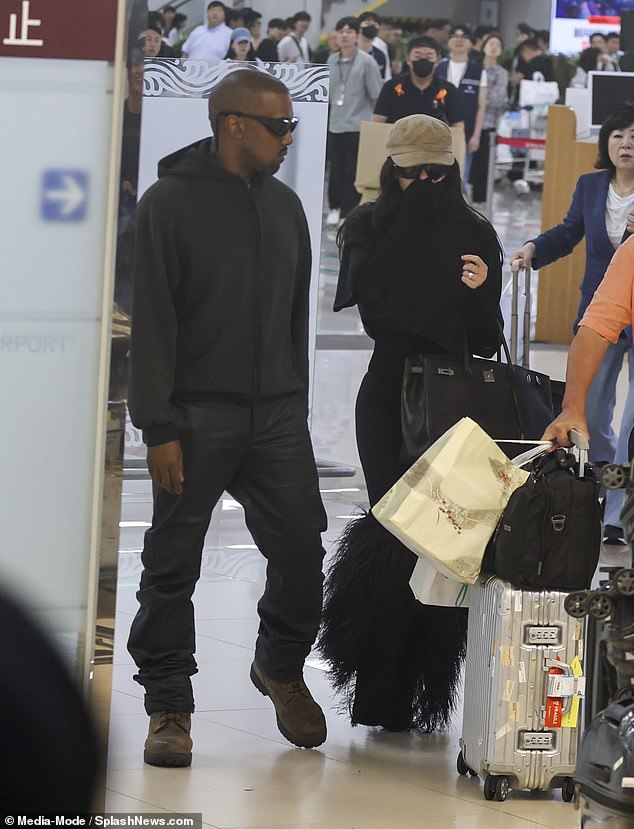 She embraced modesty for a change with her black sweater, leggings, furry leg warmers, and sunglasses