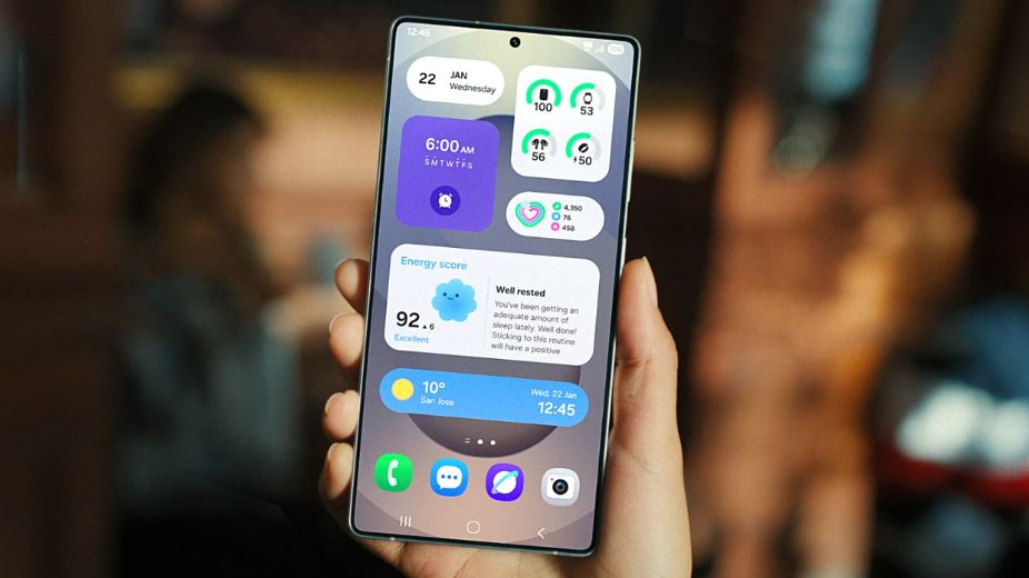 Hand holding Samsung Galaxy phone displaying One UI 8.