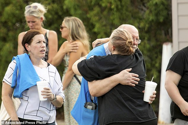 Walmart employees and customers wait outside while law enforcement investigates the scene after a stabbing incident in Traverse City, Michigan on Saturday