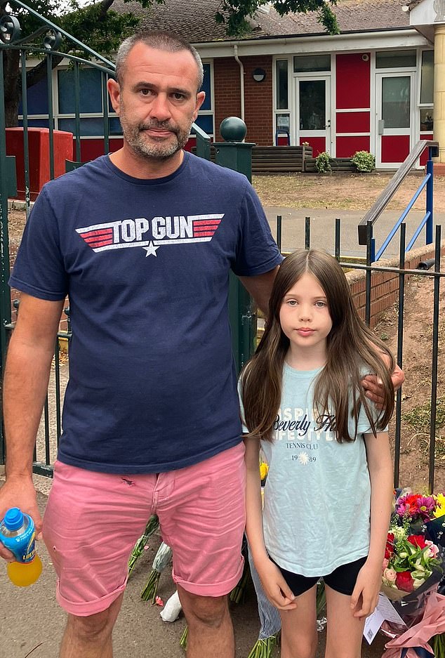 Emily (right) was among dozens of pupils, parents and local residents who laid flowers outside the front gates of the school - which is closed today following the tragedy