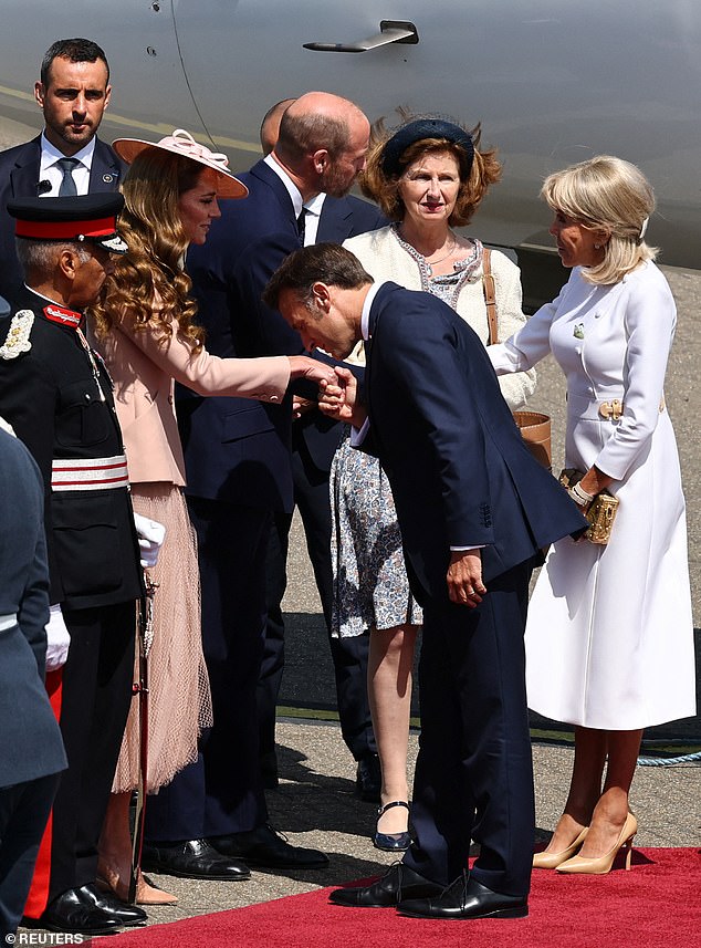Macron greeted Kate with a kiss on her hand after he landed at RAF Northolt in London ahead of his three-day visit